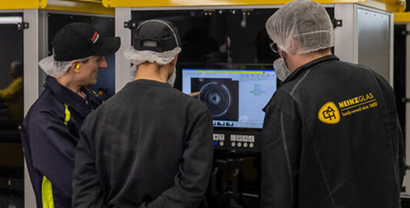 team looking at screen of inspection machine